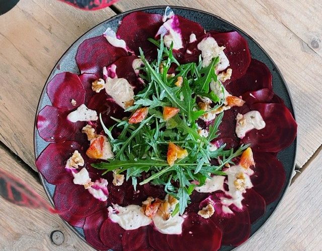 Carpaccio van rode biet met sinaasappeldressing, rucola & geitenkaas